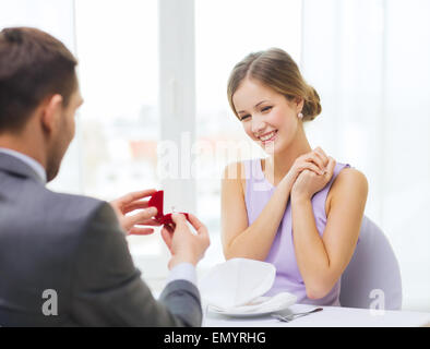 Eccitato giovane donna guardando il fidanzato con anello Foto Stock