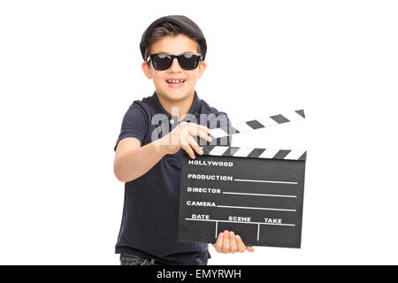 Ragazzino con gli occhiali da sole e un berretto nero per divertirsi con un film clapperboard isolati su sfondo bianco Foto Stock