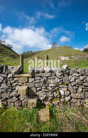 Una pietra stile su una parete di roccia calcarea nei pressi di Bradwell nel Peak District, Derbyshire. Foto Stock