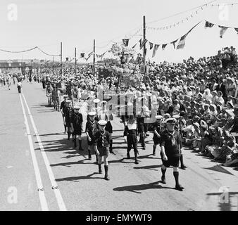 La battaglia annuale di fiori carnevale che si svolge sul canale isola di Jersey. La folla la linea della strada per guardare una processione. 5 agosto 1958. Foto Stock