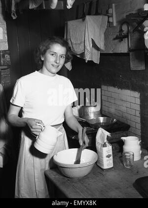 La donna vede in cucina la cottura circa Febbraio 1952 Foto Stock