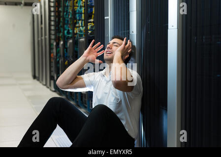 Business uomo seduto in un centro dati cercando frustrati con il sistema corrente. Egli è alla ricerca di una migliore soluzione IT. Foto Stock