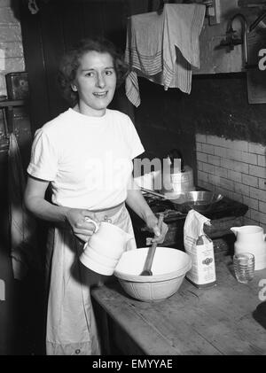 La donna vede in cucina la cottura circa Febbraio 1952 Foto Stock