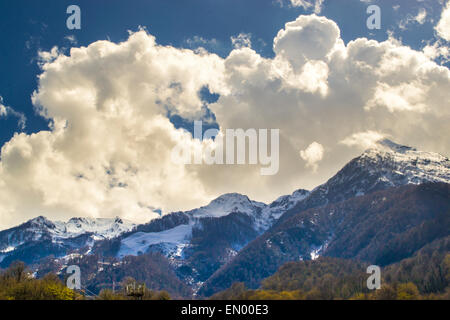 Nuvole bianche gettano ombre sulla neve il picco delle montagne Foto Stock