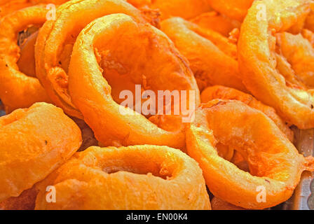 Extreme close up profondo fritto pastella immerso anelli di cipolla. Foto Stock