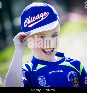 Ragazzo con lentiggini dà un sorriso impertinente per la fotocamera a una città di Warrington partita di calcio Foto Stock