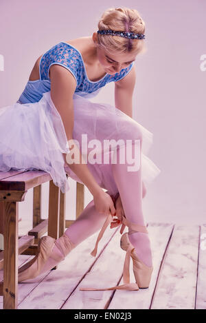 Professional ballerina mettendo sul suo scarpe da ballo. Foto Stock