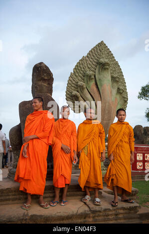 SIEM REAP, Cambogia - 30 ottobre 2014: il Principiante i monaci buddisti in arancione vesti pongono davanti all'ingresso di Angkor Wat. Foto Stock