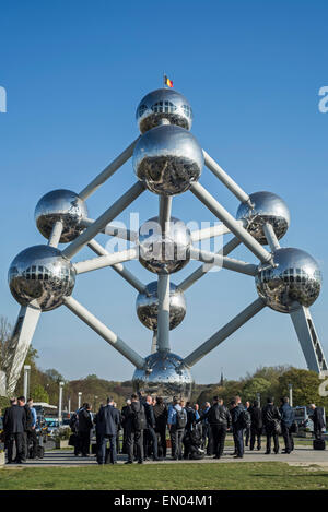 Uomini d'affari in nero si adatta in attesa nella parte anteriore del Atomium, punto di riferimento a Bruxelles originariamente costruito per Expo 58, Belgio Foto Stock