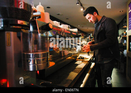 L'Aia, Paesi Bassi. 23 apr, 2015. Un giovane uomo è visto la preparazione di un caffè espresso in un bar nel centro di Hague. Credito: Willem Arriens/Alamy Live News Foto Stock