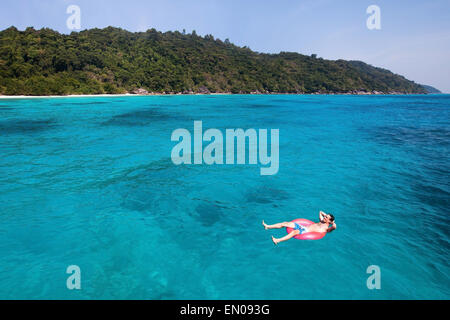 Assicurazione di viaggio concetto, uomo nuotare nel salvagente su Paradise Beach Foto Stock