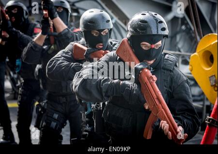 Marina militare marocchina special operations commandos stabilire la sicurezza durante una visita, scheda, ricerca e sequestro praticare a bordo i militari Sealift il comando congiunto del ad alta velocità a nave USNS Spearhead durante l'esercizio Saharan Express 22 aprile 2015 nel Golfo di Guinea. Foto Stock