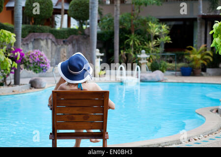 Donna relax nella spa di lusso hotel vicino alla bellissima piscina Foto Stock