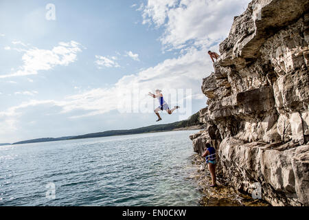 Un gruppo di amici passare da scogliere nel lago. Foto Stock
