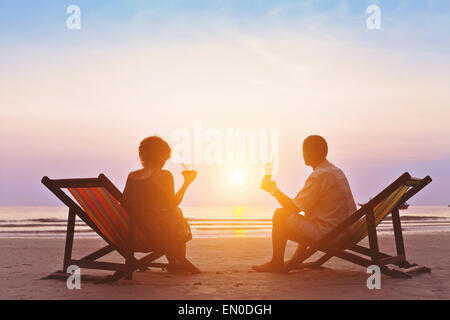 Famiglia godendo romantico tramonto sulla spiaggia Foto Stock