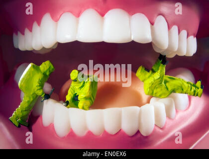 Modello di uomini in verde materiale pericoloso suites la pulizia dei denti. Foto Stock