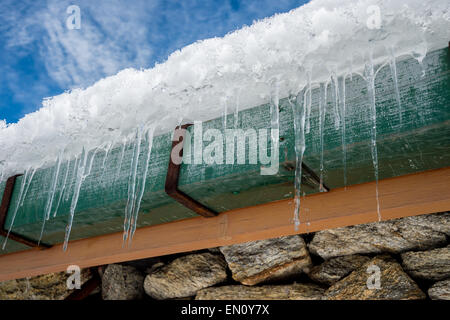 Inverno ghiaccioli appesi da gronda del tetto, in Himalaya regione, Nepal. Foto Stock