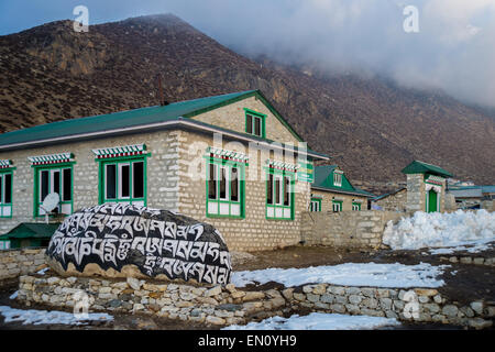 Lodge nel villaggio dingboche, everest regione, Nepal, con mani la pietra in primo piano Foto Stock