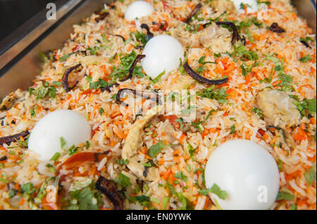 Primo piano dettaglio del pollo biryani riso con uova sul display in un ristorante indiano Foto Stock