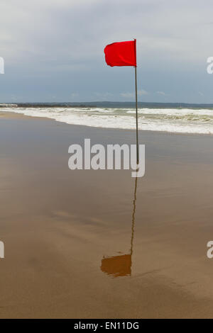 La stagione delle tempeste. Bandiera rossa sulla spiaggia Foto Stock