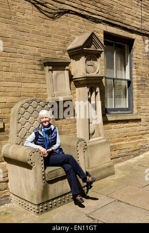 Regno Unito, Inghilterra, Yorkshire, Bradford, piccola Germania, donna sat su del nonno e di clock sedia scultura da Timothy otturatore Foto Stock