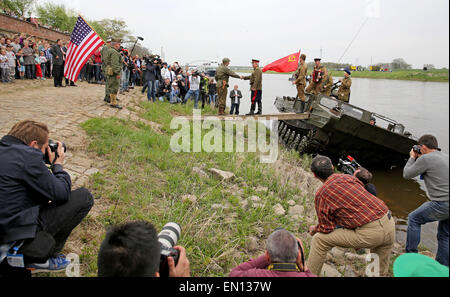 Torgau, Germania. Xxv Aprile, 2015. Due uomini reinterpreta un incontro storico tra sovietici e US (L) i soldati verso la fine della II Guerra Mondiale nei pressi di Torgau, Germania, 25 aprile 2015. Durante la "Elbe giorno' Torgau celebra il settantesimo anniversario dell incontro tra sovietici e noi esercito verso la fine della Seconda Guerra Mondiale. La mostra al Castello di Hartenfels corre dal 24 aprile al 31 maggio e include 30 schede con fotografie storiche a partire dalla fine della Seconda Guerra Mondiale. Foto: JAN WOITAS/dpa/Alamy Live News Foto Stock