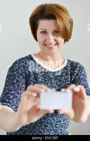 Donna adulta tenendo un white business card in mano Foto Stock