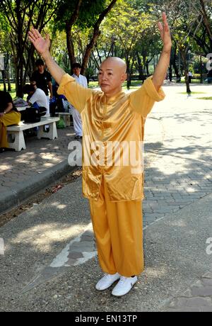 Bangkok, Thailandia: uomo tailandese tradizionale che indossano vestiti di seta di eseguire il Tai Chi esercita nel Parco Lumphinee Foto Stock