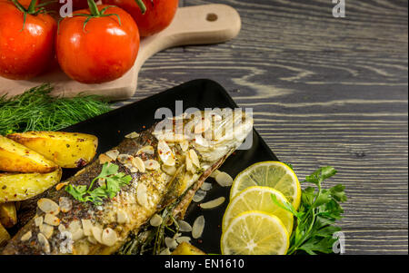 Trota fritta con mandorle, aneto e Spicchi di patate Foto Stock