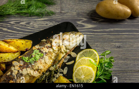 Trota fritta con mandorle, aneto e Spicchi di patate Foto Stock