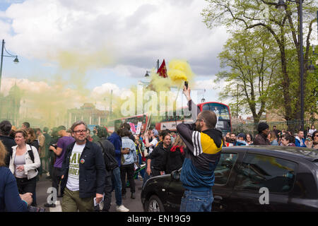 Brixton, Londra, 25 aprile 2015 un manifestante accende una svasatura di emergenza come anti-gentrification manifestanti marzo attraverso Brixton a Londra. Credito: Patricia Phillips/Alamy Live News Foto Stock