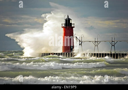 Onda selvaggia di schiantarsi su un faro rosso alla fine di un molo in Sud Haven, Michigan. Foto Stock