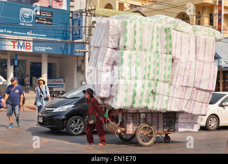 Chiang Rai, Mae Sae, posto di frontiera con la Birmania, Myanmar. Nel nord della Thailandia. Commerciante contadina combatte con un enorme carrello di merci Foto Stock