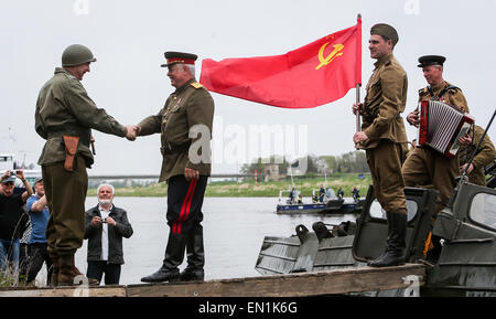 Torgau, Germania. Xxv Aprile, 2015. Attori dilettanti, riprendendo la famosa riunione dei sovietici e soldati americani nel corso delle celebrazioni per il settantesimo anniversario dell'Elba giorno in Torgau, Germania, il 25 aprile 2015. Migliaia di visitatori si sono riuniti sabato nel nord della città tedesca di Torgau per contrassegnare il settantesimo anniversario del famoso e simbolico agitando a mano di americani e soldati sovietici durante la II Guerra Mondiale su una rovina ponte che attraversa il fiume Elba a Torgau. Credito: Zhang ventola/Xinhua/Alamy Live News Foto Stock