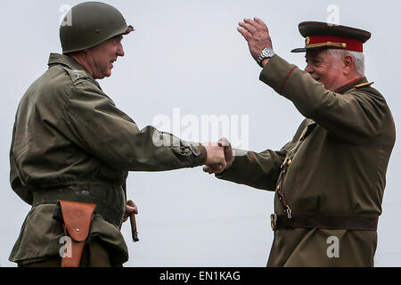 Torgau, Germania. Xxv Aprile, 2015. Attori dilettanti, riprendendo la famosa riunione dei sovietici e soldati americani nel corso delle celebrazioni per il settantesimo anniversario dell'Elba giorno in Torgau, Germania, il 25 aprile 2015. Migliaia di visitatori si sono riuniti sabato nel nord della città tedesca di Torgau per contrassegnare il settantesimo anniversario del famoso e simbolico agitando a mano di americani e soldati sovietici durante la II Guerra Mondiale su una rovina ponte che attraversa il fiume Elba a Torgau. Credito: Zhang ventola/Xinhua/Alamy Live News Foto Stock