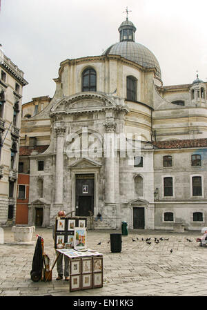 7 ottobre, 2004 - Venezia, Provincia di Venezia, Italia - a San Geremia Square, nel sestiere (quartiere) di Cannaregio, un venditore ambulante vende artwork di fronte a San Geremia chiesa. Prima costruita nell' XI secolo e ricostruito nel XVIII secolo, ha due facciate simili, uno affacciato sul Canal Grande, e l'altro, l'ingresso, qui mostrato, rivolto verso la piazza. La sua muratura è il campanile del XII secolo. Dedicato ai due santi: San Geremia e Santa Lucia (St. Lucia), è popolare come il centro del culto di Santa Lucia di Siracusa, i cui resti sono alloggiati all'interno, visitato da pellegrini provenienti da tutti i Foto Stock