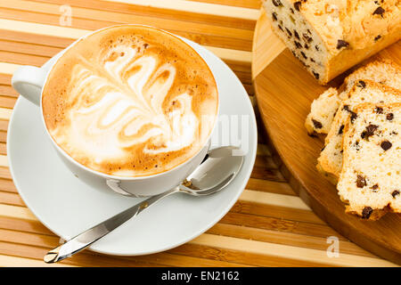 Tazza di cappuccino e torte su sfondo di legno Foto Stock