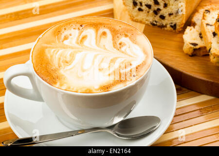 Tazza di cappuccino e torte su sfondo di legno Foto Stock