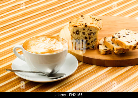 Tazza di cappuccino e torte su sfondo di legno Foto Stock