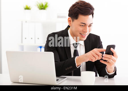 Felice giovane imprenditore lavora con smart phone Foto Stock