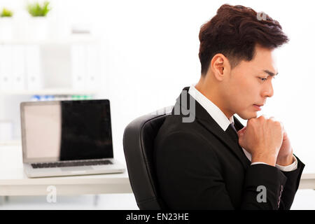 Giovane uomo d affari pensando in ufficio Foto Stock