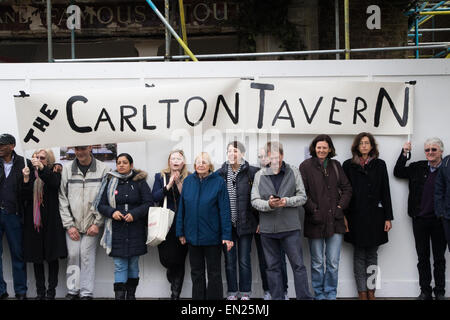 Maida Vale, London, 26 aprile 2015. Decine di residenti locali e assidui frequentatori di raccogliere al di fuori il tanto amato, parzialmente demolito Carlton Tavern a Maida Vale per protestare contro la sua improvvisa e demolizioni illegali dagli sviluppatori di proprietà. Essi esigono che il pub, ricostruita nel 1920 a seguito di una guerra mondiale uno Zeppelin bombardamento è ancora una volta ricostruita mattone-da-mattone, dicendo che le eventuali multe da parte del consiglio avrà een scomposto nel bilancio dello sviluppo. Foto Stock