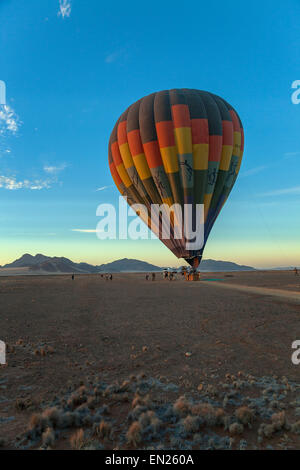 Una mongolfiera essendo preparato all'alba, Namibia. Foto Stock