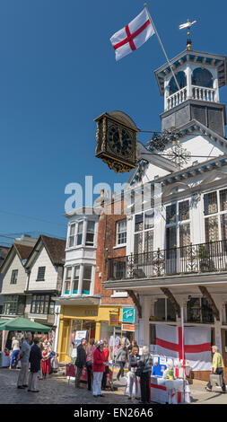 Il mensile regolare mercato degli agricoltori sul lastricato Guildford High Street con la Guildhall sopra di orologio Foto Stock
