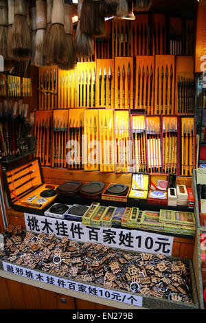 La calligrafia i pennelli utilizzati nella scrittura e disegno in vendita su una bancarella di strada, Shanghai, Cina Foto Stock