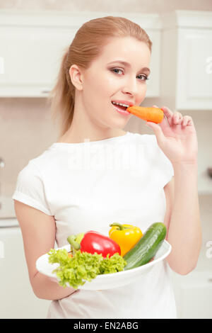 La donna trattiene la piastra con verdure Foto Stock