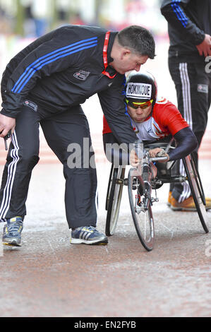 Londra, Regno Unito. 26 apr, 2015. Gli ufficiali di gara aiutando Kota Hokinoue con la sua sedia dopo un crash in dirittura d'arrivo del denaro Virgin London Marathon, domenica 26 aprile 2015. Egli è venuto 7th. Credito: Michael Preston/Alamy Live News Foto Stock