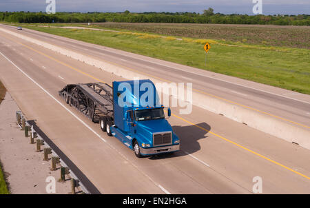 Un big Rig car hauler rotola giù l'autostrada intitolata a prelevare il carico successivo Foto Stock