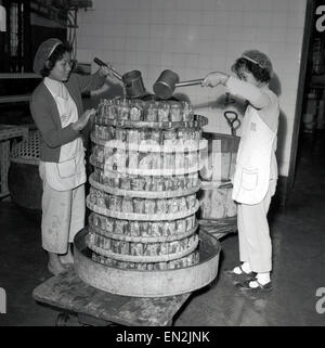 Anni '50, storica, in una fabbrica, due giovani lavoratrici cinesi, indossando retine, versando resina su muffe giocattolo, Hong Kong. La sua posizione, lo spirito imprenditoriale e il porto naturale hanno visto la regione diventare un epicentro per la produzione di plastica su piccola scala e la produzione e l'esportazione di giocattoli e prodotti associati. Foto Stock