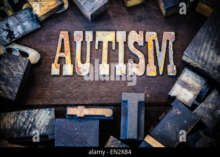 La parola autismo scritto in metallo arrugginito lettere circondato da vintage in legno e metallo tipo di stampa in rilievo. Foto Stock